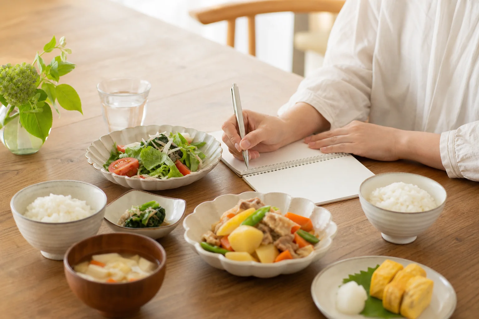 在宅訪問の場面で家庭の食卓を前に食事の工夫を考えるイメージ写真